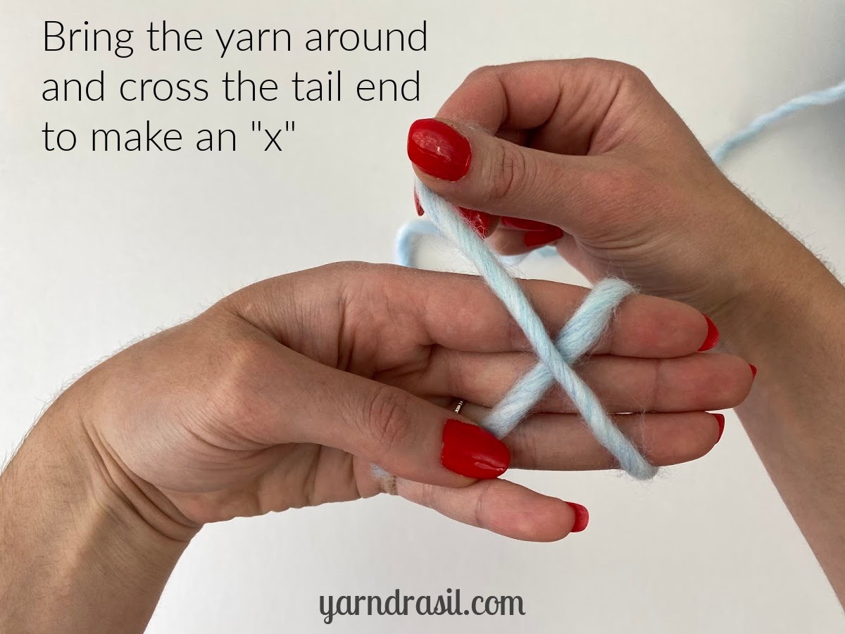 Bring the yarn around and cross the tail end to make an "x"