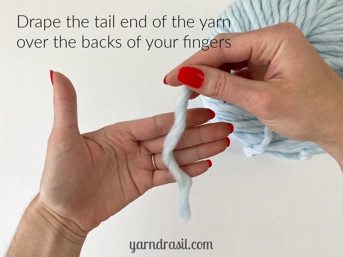 Drape the tail end of the yarn over the backs of your fingers