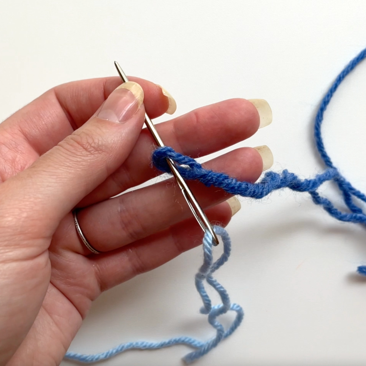 Thread the new yarn through the loop that you just made